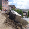 Kamyon evin çatısına devrildi Kamyon evin çatısına devrildi